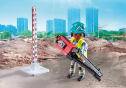 Playmobil-Figur in Baukleidung mit einem Werkzeug in der Hand. Messlatte im Hintergrund.