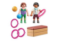 Zwei Playmobil-Figuren, eine mit Ball und eine mit Reifen. Dazu drei pinke Ringe und eine Turnbank.