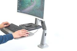 Monitorarm aus silbernem Metall mit einer Halterung für einen Bildschirm. Eine Ablagefläche ist ebenfalls vorhanden.