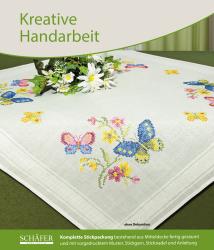 Tischdecke mit bunten Schmetterlingen und Blumen. Das Design ist gestickt und farbenfroh.