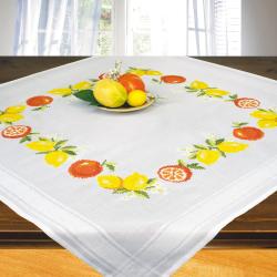 Tischdecke mit buntem Obstmuster. Auf dem Tisch liegt eine Schale mit verschiedenen Früchten.