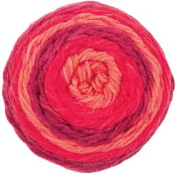 Wollknäuel in warmen Farbtönen von Rosa bis Rot. Verpackung mit Anleitung für ein Dreieckstuch.