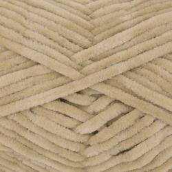 Wolle in hellem Beige für Strickprojekte. Auf dem Etikett eine Anleitung für eine Mütze.