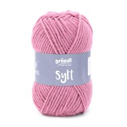 Rosa Wollknäuel mit der Aufschrift Sylt. Das Material wirkt weich und eignet sich zum Stricken.