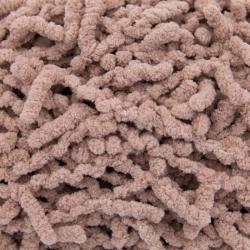 Garnknäuel in beige mit einer strukturierten Oberfläche. Verpackung zeigt den Namen 'Flipsy' und eine Anleitung für einfache Strickprojekte.