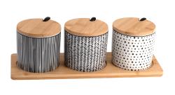 Drei Aufbewahrungsgläser mit Holzdeckeln. Schwarz-weiße Muster und ein Holztablett.