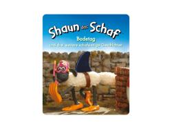 Figur eines Schafes mit schwarzem Gesicht und Beinen. Steht auf einem Heuballen. Neben der Figur ein Buchcover mit dem Titel 'Shaun das Schaf: Badetag' und weiteren Geschichten.
