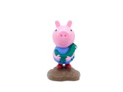 Figur von Peppa Wutz in blauer Kleidung. Im Hintergrund ein Buch mit dem Titel 'Die schönsten Geschichten von Schorsch'.