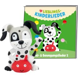 Ein Spielzeughund mit schwarzen Punkten und einem roten Körper. Im Hintergrund ein Buch mit dem Titel 'Lieblings-Kinderlieder'.