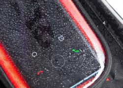 Schwarze Fahrradtasche mit rotem oberen Teil. Sie hat ein durchsichtiges Fenster und einen Reißverschluss.