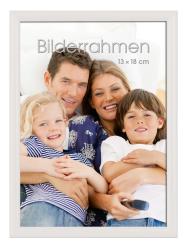 Familienfoto mit vier Personen. Lächelnde Gesichter, entspannte Pose. Kinder in gestreiften Shirts, Erwachsene in lässiger Kleidung. Sofaeinstellung.