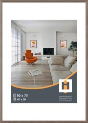Helles Wohnzimmer mit einem orangefarbenen Sessel. Es gibt einen Tisch und zwei Bilder an der Wand.