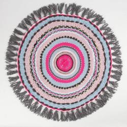 Runder Teppich mit bunten, konzentrischen Kreisen in Rosa, Blau und Grau. Mit fransenartigem Rand.