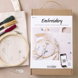 Bastelset für Stickerei mit einem Stickrahmen und Blumenmotiv. QR-Code für ein Online-Tutorial vorhanden.