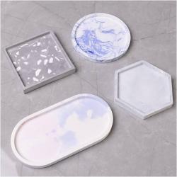 Vier weiße Platten in verschiedenen Formen: oval, rund, quadratisch und sechseckig. Alle Platten sind flach und ohne Muster.