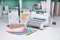 Stanzmaschine mit buntem Papier und Stanzformen. Zubehör für Bastelarbeiten.
