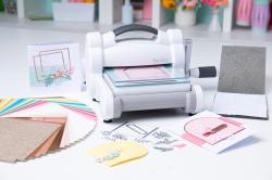 Stanzmaschine mit buntem Papier und Stanzformen. Zubehör für Bastelarbeiten.