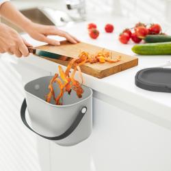 grauer Eimer mit schwarzem Deckel und Henkel. Ovaler Körper, schlichtes Design.