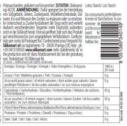 Glasbehälter mit weißem Deckel. Inhalt ist ein gelbes Sirup mit Nährwertangaben auf der Rückseite.