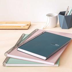 Drei spiralgebundene Notizbücher in verschiedenen Farben. Ein grünes, ein rosa und ein dunkelblaues Notizbuch.