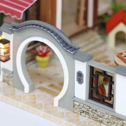 Modell eines zweigeschossigen Hauses im asiatischen Stil. Dach mit Schindeln, Balkon, Wasserstelle, Garten mit Pflanzen und einem Wasserrad.