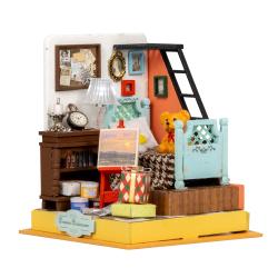 Miniaturzimmer mit Bett, Leiter und Tisch. Bunte Wände, Bilderrahmen, Lampe. Spielzeugbär auf dem Bett. Malerei auf Staffelei. Bücherregal und Geschenke.