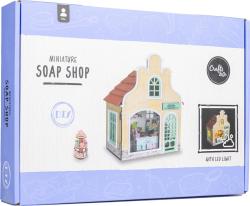 Verpackung für ein Miniatur-Seifenladen-Bausatz. Enthält ein Modell mit LED-Licht und einem kleinen Verkaufsstand.