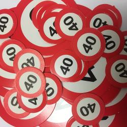 Viele rote Plaketten mit der Zahl 40. Runde Form, weißer Hintergrund.