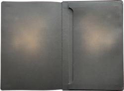 Schwarzes Notizbuch mit einem Bild einer Glühbirne auf dem Cover. Die Glühbirne leuchtet orange.
