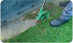 Grüner elektrischer Rasentrimmer mit zwei großen Rädern. Langer Griff und ergonomischer Handgriff.