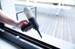 Handstaubsauger in Schwarz mit transparentem Behälter. Ergonomischer Griff und schmaler Aufsatz.