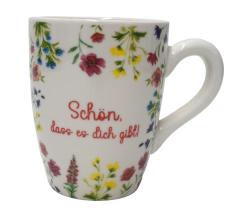 Weiße Tasse mit bunten Blumenmustern. Auf der Tasse steht der Text: 'Schön, dass es dich gibt!'