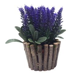 Künstliche Pflanze mit lila Blüten und grünen Blättern. Topf aus kleinen Holzstücken.