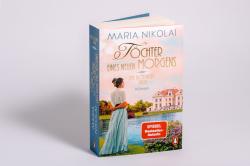 Buchcover von 'Töchter eines neuen Morgens'. Eine Frau in einem langen, hellen Kleid steht vor einem Schloss am Wasser.