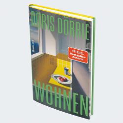 Buchcover von 'Wohnen' von Doris Dörrie. Gelbe Küchenoberfläche mit Äpfeln auf einem Teller.