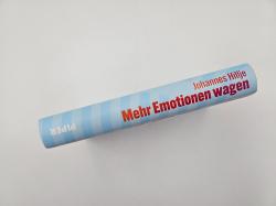 Buchcover mit dem Titel 'Mehr Emotionen wagen'. Farbige Schrift auf hellem Hintergrund, einfache Gestaltung.