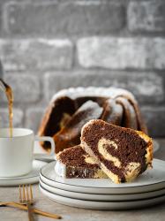 Buchcover mit dem Titel 'Mann backt Kuchen'. Abgebildet ist ein Gugelhupf mit einer hellen Füllung und Puderzucker.
