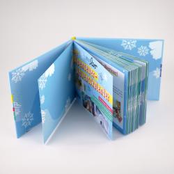 Blaues Adventskalenderbuch mit Schneeflocken-Design. Mehrere Seiten sichtbar, vermutlich mit Bildern und Texten für Kinder.