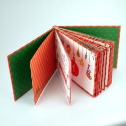 Aufklappbares Adventskalenderbuch mit roten und grünen Seiten. Dekorative Weihnachtsmotive und kleine Bilder im Inneren.