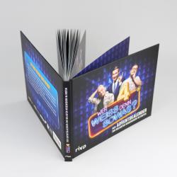 Buch mit dunklem Cover, zeigt drei lachende Männer vor einem blauen Hintergrund mit Tannenbäumen. Titel: Wer weiss denn Sowas, Adventskalender.