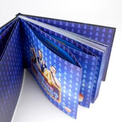 Buch mit blauer, mit Tannenbäumen bedruckter Umschlag. Vorderseite zeigt ein Bild mit zwei Personen und einer großen Zahl vier, vermutlich ein Jubiläum.