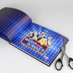 Offenes Buch mit blauer Hintergrundseite und einem Muster aus kleinen blauen Dreiecken. Auf der rechten Seite sind drei lachende Menschen mit unterschiedlichen Posen abgebildet. Darunter ein neonfarbenes Textbanner mit der Frage Wer Weiss Denn 4 SOWAS.