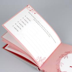 Offenes Adventskalenderbuch mit rosa und weißen Farben. Innen sind Linien für Eintragungen, mit weihnachtlichem Dekor an den Rändern.