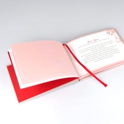 Offenes Buch mit rosa und weißen Seiten. Auf der rechten Seite ist Text in deutscher Sprache, mit roten Akzenten und einer roten Leseband.