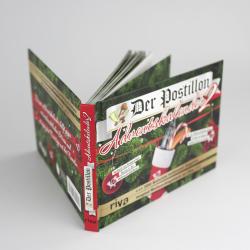 Buch mit grünem und rotem Cover, Titel Der Postillon Adventskalender. Zeigt einen Stift in einem roten Becher und Weihnachtsmotive.