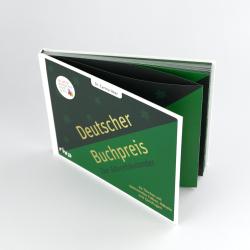 Grünes Buch mit weißen und schwarzen Elementen auf dem Cover. Der Titel lautet Deutscher Buchpreis Der Adventskalender.