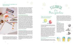 Bunte Aquarellfarben in einer offenen Palette, Pinsel und Papier liegen auf einem weißen Tisch. Das Bild zeigt eine kreative Malumgebung für Mangakas.