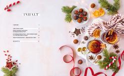 Weihnachtliche Dekoration mit Tannenzweigen, Zimtstangen, Orangen, Schokoladentrüffeln und Pralinen auf einem weißen Hintergrund. Es gibt auch Glühwein in Gläsern, Lichterketten und weihnachtliche Süßigkeiten.