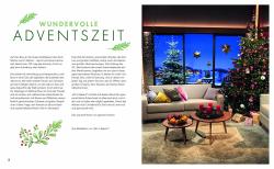 Innenseite eines Wohnzimmers mit großen Fenstern, Weihnachtsbaum mit roten und weißen Kugeln, Geschenke darunter, zwei Sofas mit bunten Kissen, zwei kleinen Tischen mit Kerzen und Obst, winterliche Landschaft draußen sichtbar.