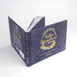 Buch mit dem Titel 'Positive Affirmationen für mich'. Dunkelblauer Einband mit goldenen Sternen und einem dekorativen Design.